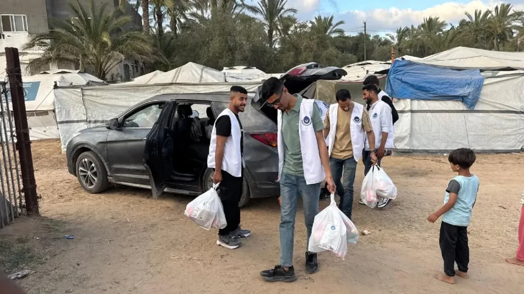 Bénévoles distribuant des sacs dans un camp