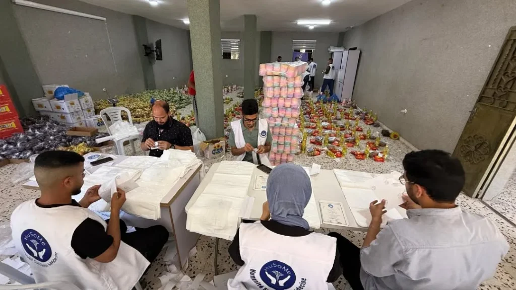 Volunteers assembling food aid packages indoors