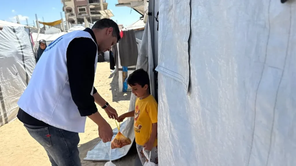 Homme distribuant de la nourriture à un enfant