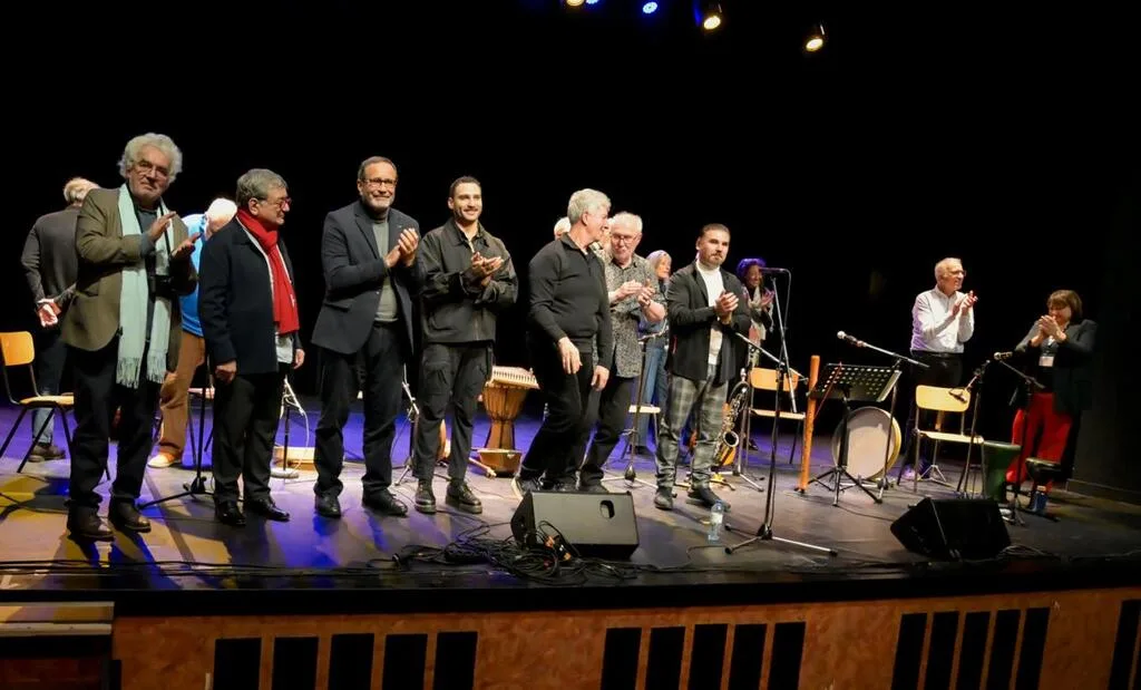 Groupe d’hommes applaudissant sur une scène.