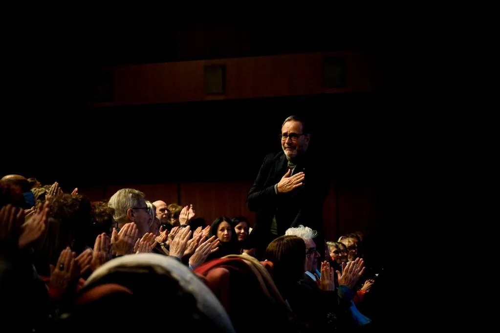 Homme reçoit des applaudissements dans une salle.