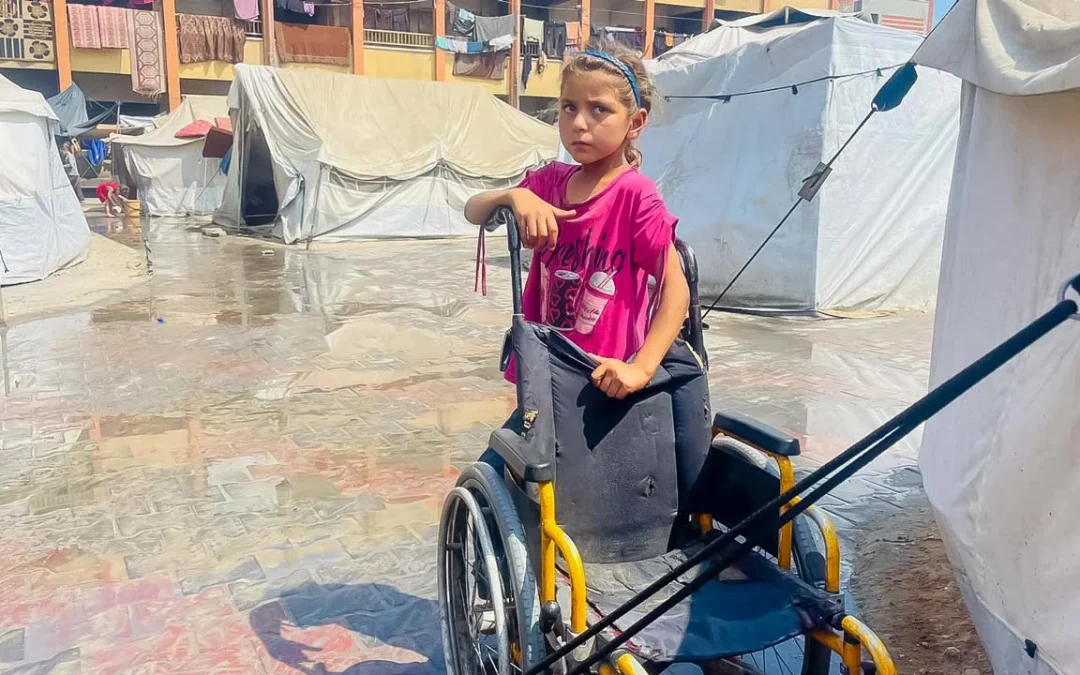 Fille en fauteuil roulant dans un camp de réfugiés.