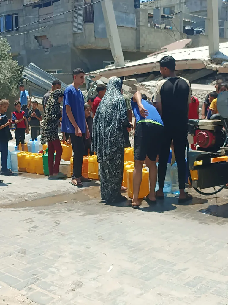 Personnes collectant de l’eau après une catastrophe.