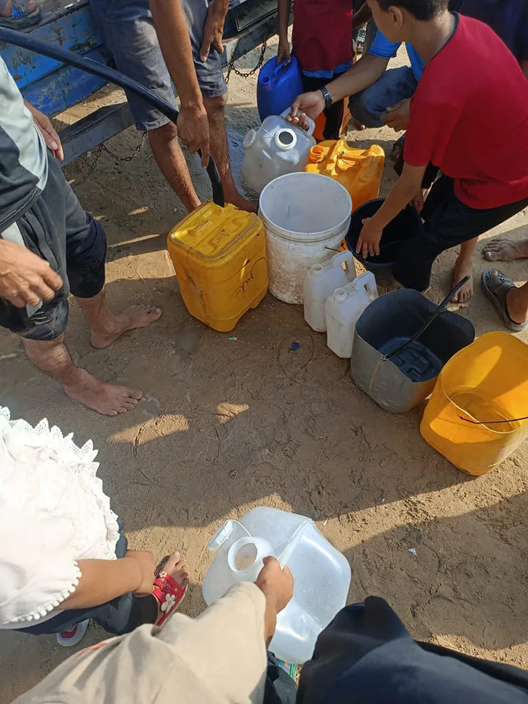 Distribution d’eau dans des bidons colorés.