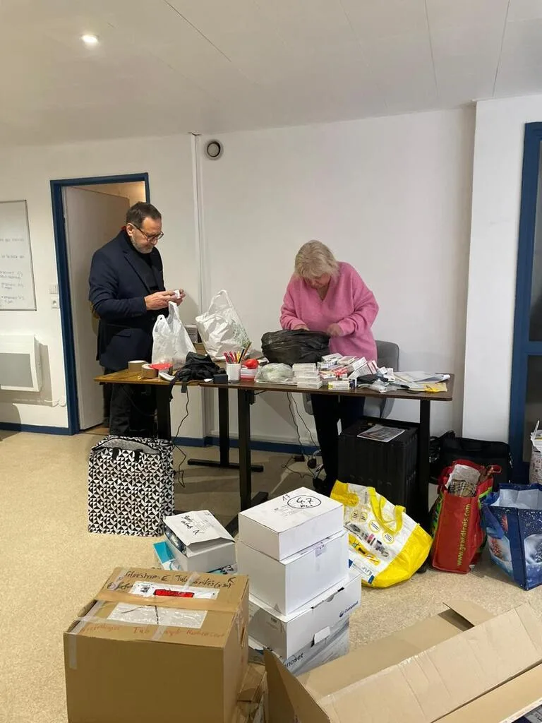 Deux personnes organisent des fournitures sur une table.
