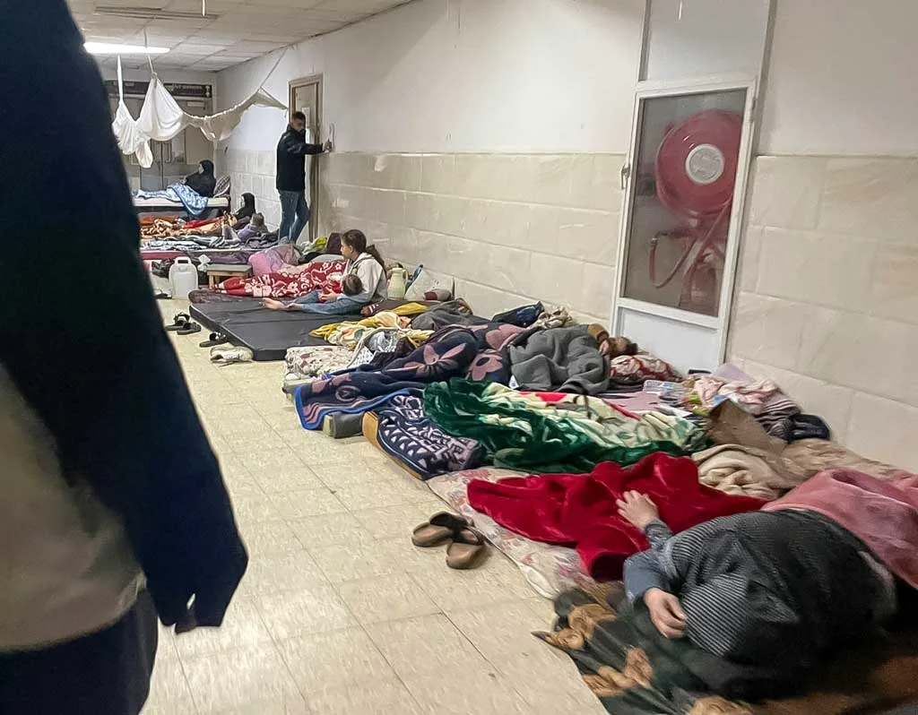 Personnes couchées dans un couloir avec couvertures