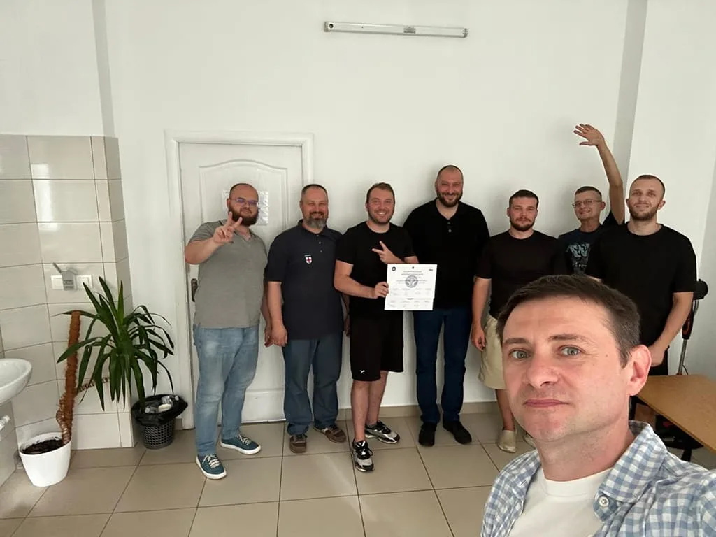 Groupe d’hommes posant avec un diplôme.