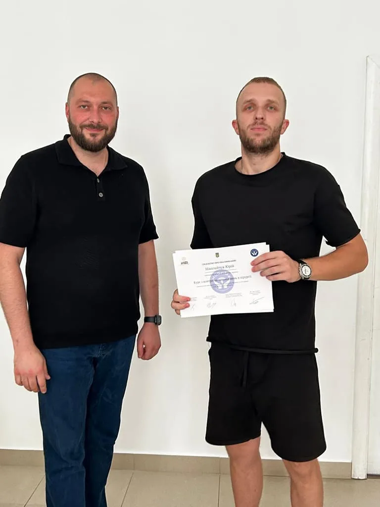 Deux hommes, l’un tient un certificat.