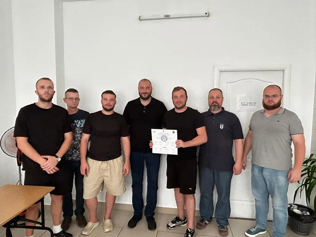 Groupe d’hommes posant avec un diplôme.