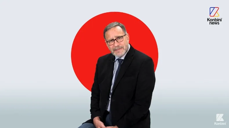 Homme en costume devant un cercle rouge, Konbini News.