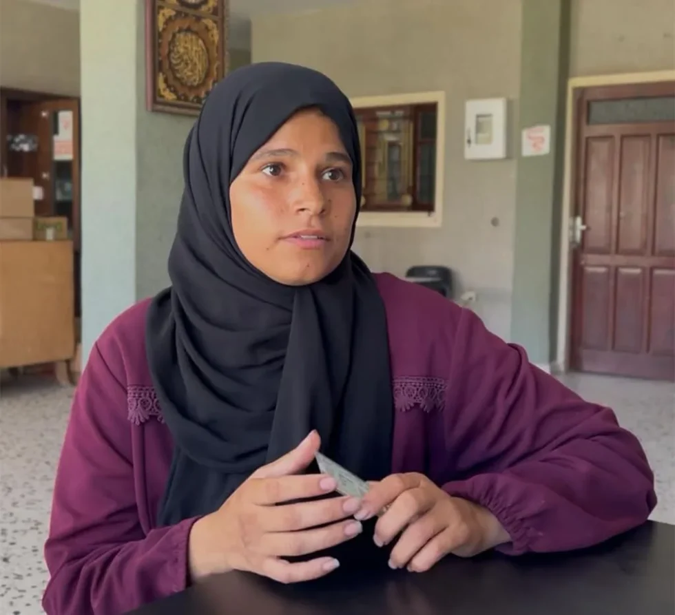 Femme portant un hijab, assise avec une carte.